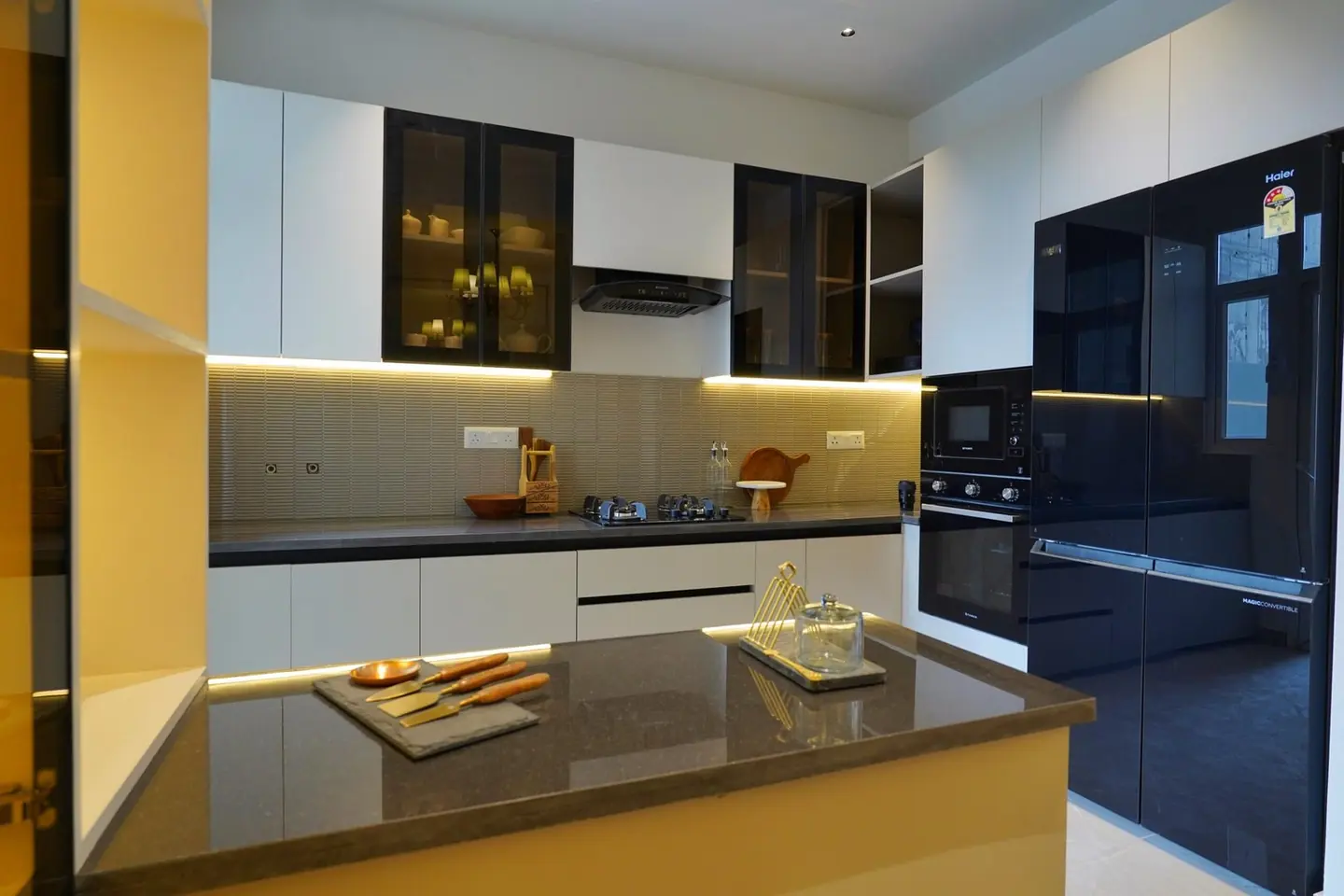 Photograph of the fitted modular kitchen in the AIGIN Royal Park sample apartment, showing the stone counter and tiled dado as built
